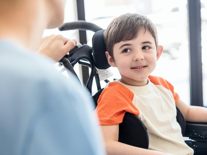 Bub im Rollstuhl mit Krankenpflege