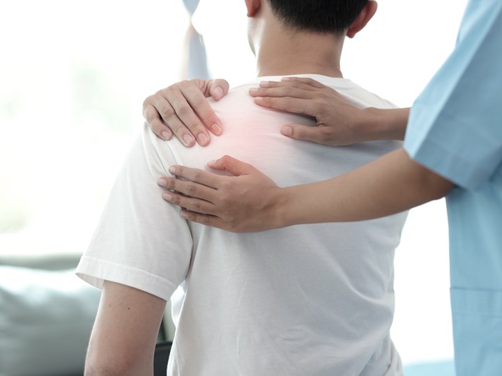 Patient und Krankenpflege tasten linke Schulter ab