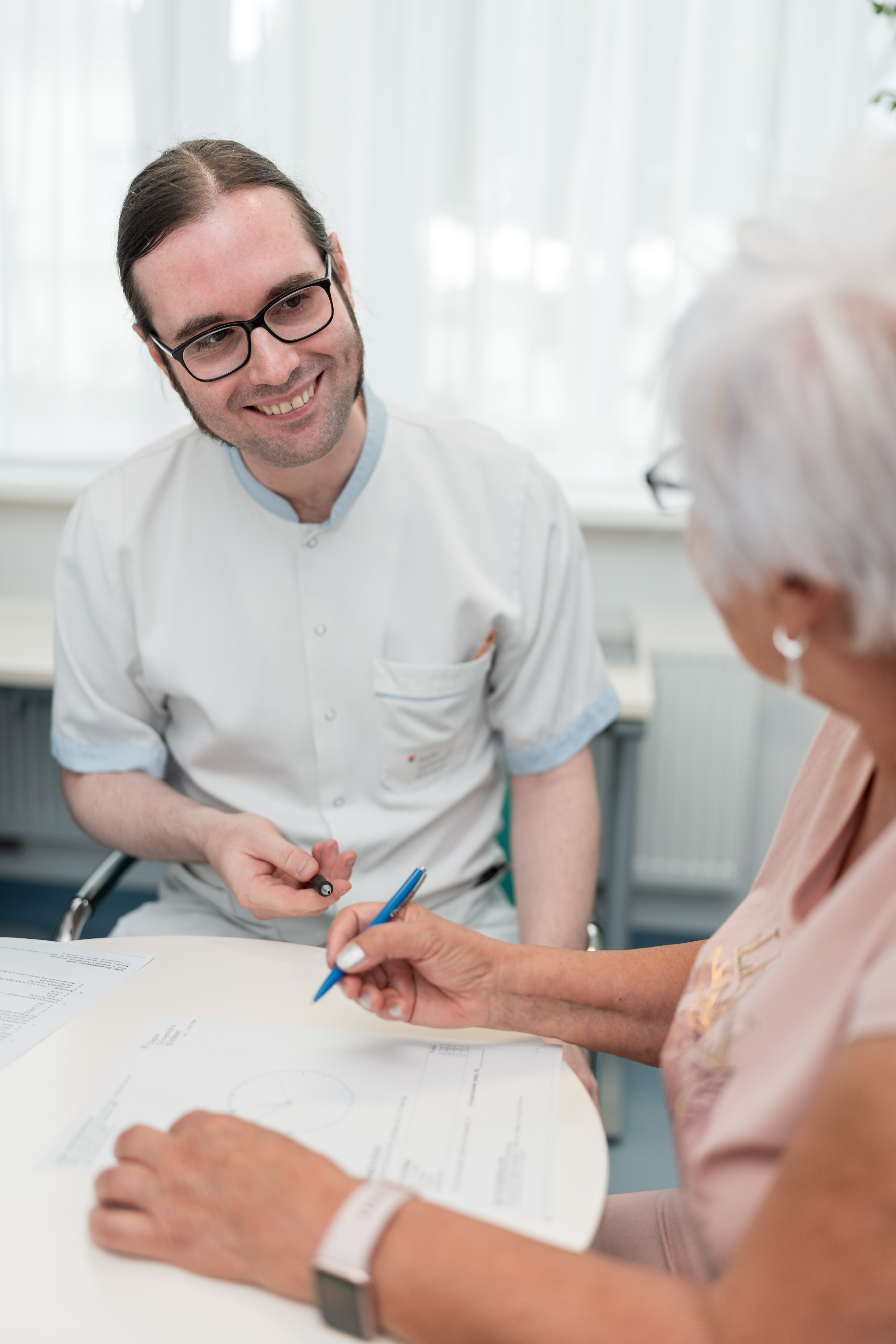 Pflegekraft beim Gehirntraining mit Patientin