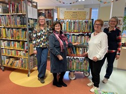 Ehrenamtliche Mitarbeiterinnen mit einem der Bücherwagen