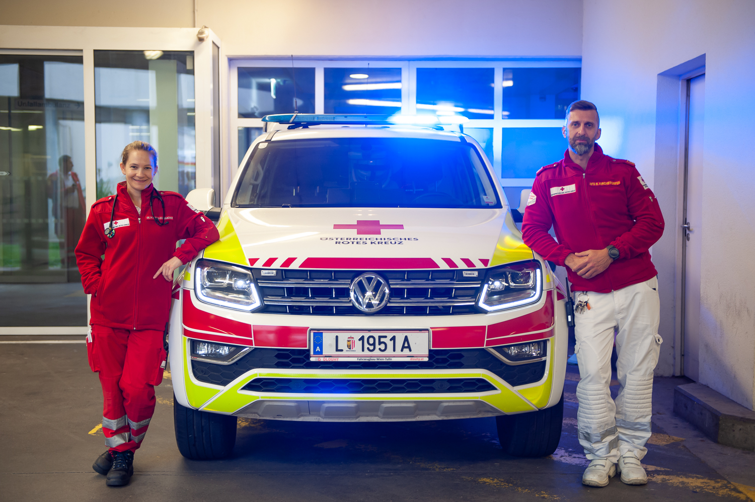 Sanitäter und Notarzt stehen beim Notarztauto