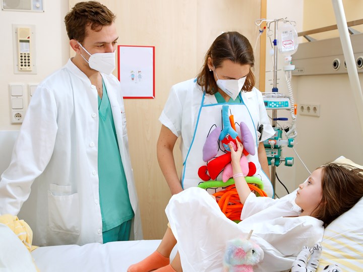 OÄ Dr. Ludwiczek und Prim. Dr. Kargl mit Kind beim Krankenbett