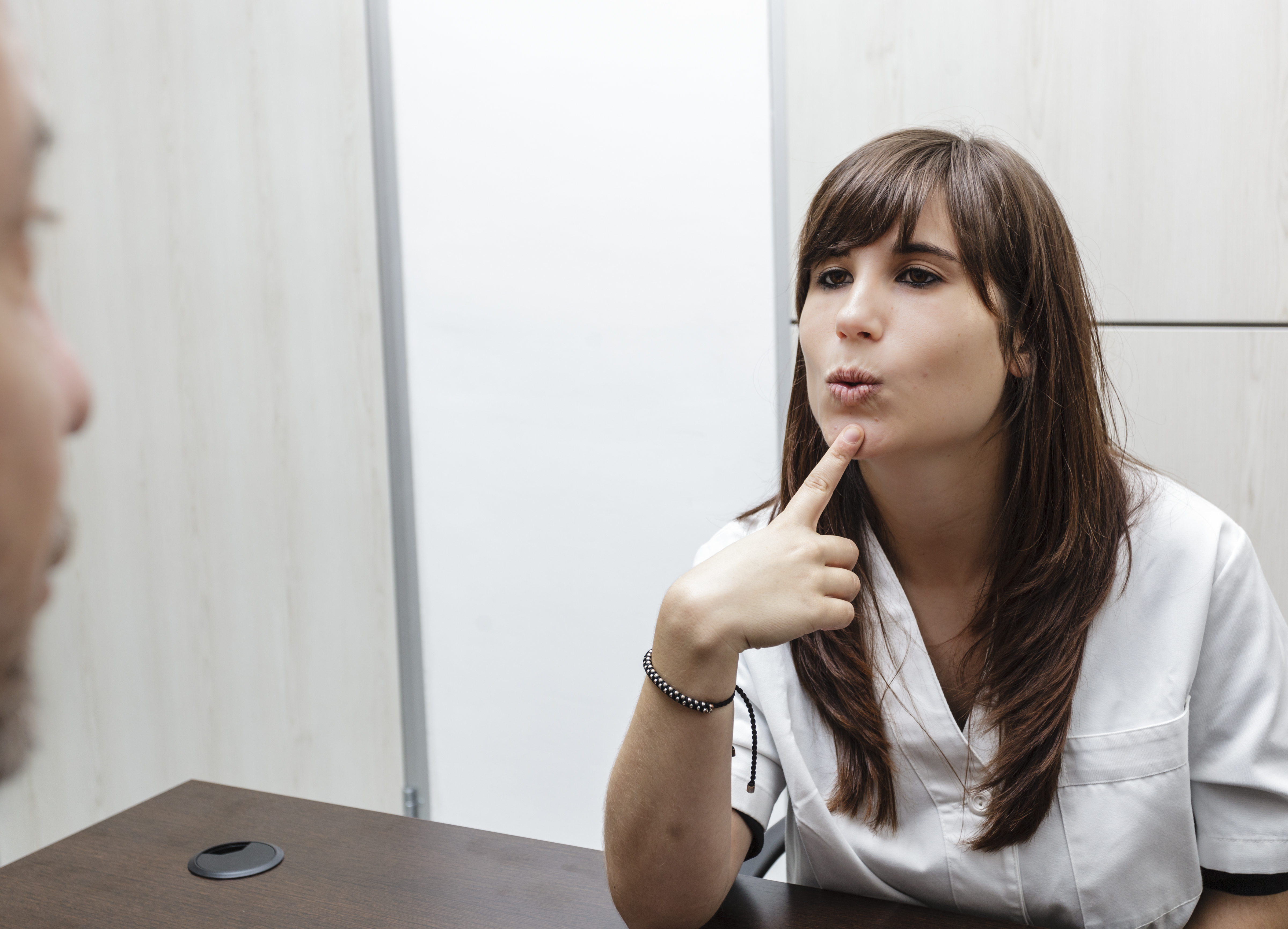 Logopädin zeigt auf Mund